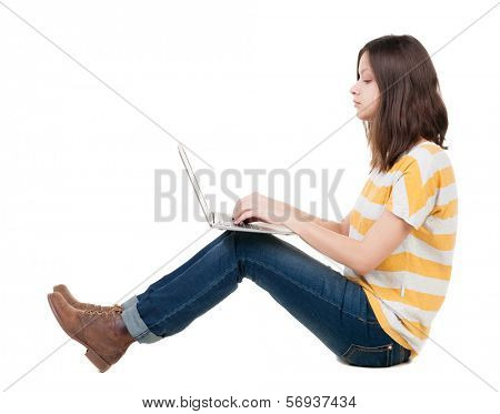 Woman sitting on floor with laptop. Isolated over white background.
