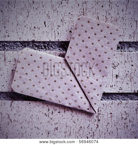 an origami heart on a brick wall with a retro effect