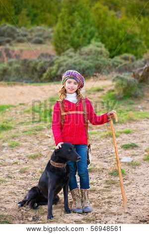 Kid girl shepherdess happy with dog flock of sheep and wooden stick in Spain