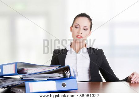 Sad woman with ringbinders sitting at the desk. Tired and exhousted business woman. 