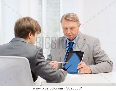 business, advertisement, technology and office concept - older man and young man with tablet pc computer in office