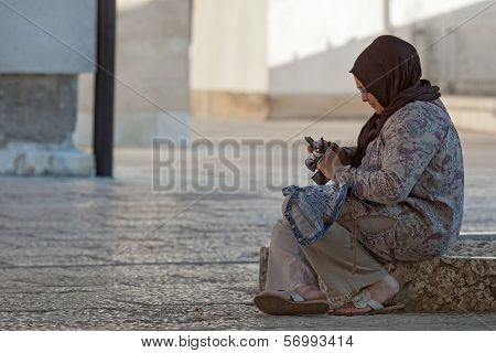 SARAJEVO, BOSNIA AND HERZEGOVINA - AUGUST 12, 2012: Muslim woman sits on floor at Gazi Husrev-Beg Mosque.