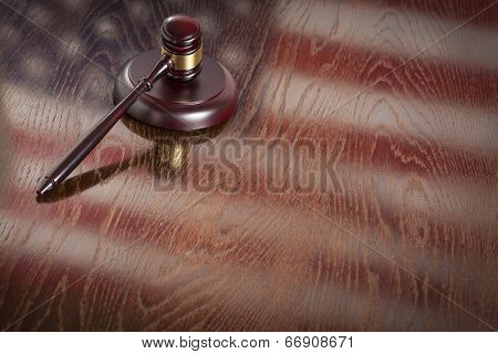 Wooden Gavel Resting on American Flag Reflecting Table.