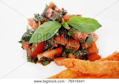 vegetable salad : cherry tomatoes and basil with sweet baked potato served on white plate with sauceboat full blask soy sauce on wood