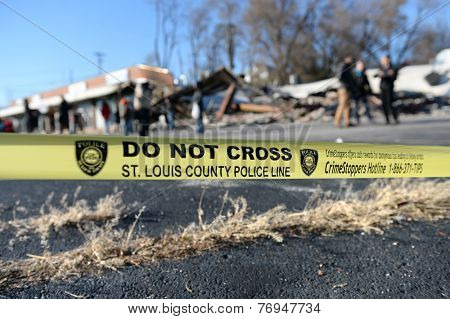 FERGUSON, MO/USA - NOVEMBER 25, 2014: Police yellow tape in front of smoldering remains of Prime Beauty Supply in Ferguson in the aftermath of riots.