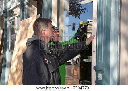 FERGUSON, MO/USA - NOVEMBER 25, 2014: Men work to board up windows in Ferguson as business in the aftermath of riots.