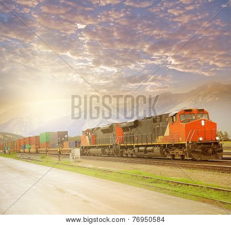 Freight train in Canadian rockies at sunset.