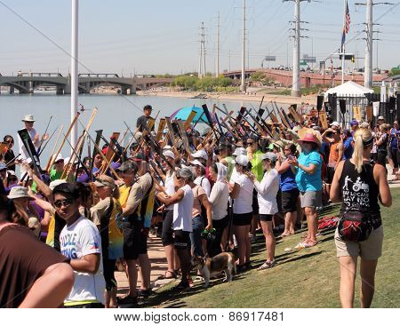 Crowd raises paddle for cancer survivor teams at Dragon Boat Races.