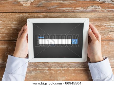 business, people, search, web and technology concept - close up of male hands using internet browser on tablet pc computer and coffee cup at table