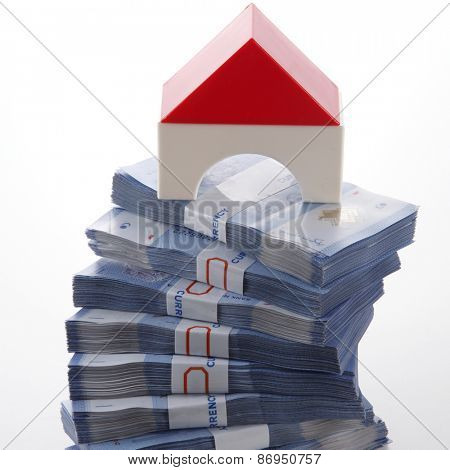 modal house on top of money stacked high