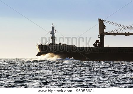 waves breaking on the nose of the big ship