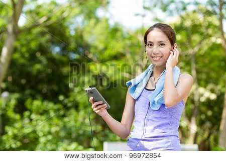 Sporty woman hold with cellphone and listen to music