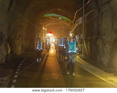 STOCKHOLM SWEDEN - MAR 25 2017: Rear view of many runners in reflex vest in a dark tunnel in the Stockholm Tunnel Run Citybanan 2017. March 25 2017 in Stockholm Sweden