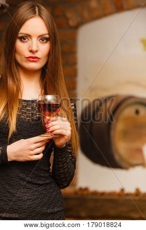Woman Tasting Wine In Rural Cottage Interior
