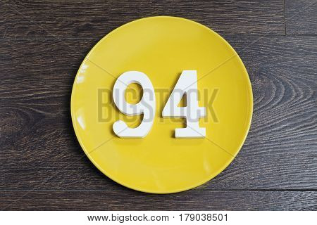 Numeral ninety-four on the yellow plate and brown background.