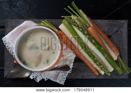 Spring season - white and green fresh asparagus cream- soup ready to eat with vegetables