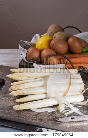 Ingredienrs for seasonal spring tasty vegetarian dinner - fresh white and green asparagus carrot potato and chicken eggs ready to cook.