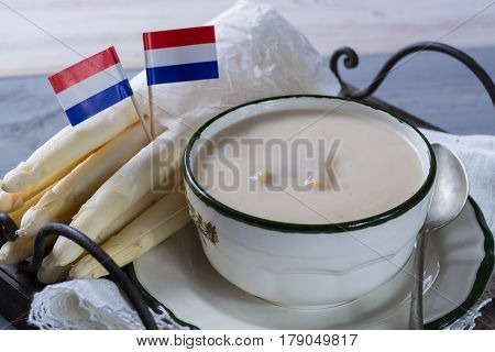 Spring season - white Dutch asparagus cream-soup ready to eat with Dutch flags