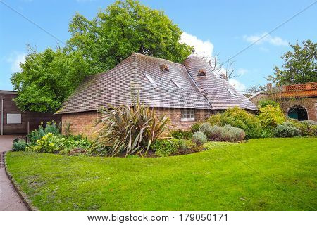View of a brick cottage under the tree in Holland Park London.