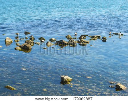 The pure blue water and stones in the sea