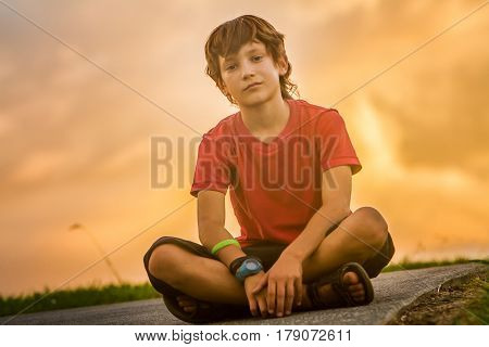 outdoor portrait of young teen boy on sunset natural background