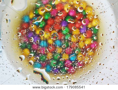 drop of water on clear plastic plate and colorful bell background