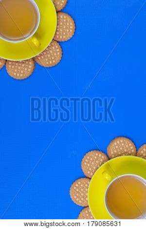 Funny arrangement cups of tea on blue wooden table with sweet cookies - Flat lay image