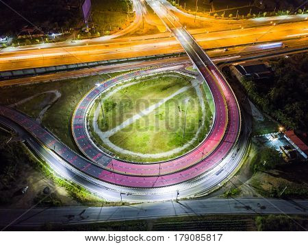 Night scene of transportation infrastructure at T-junction with the overpass aerial view Thailand