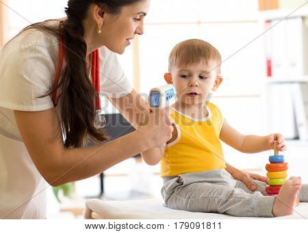 doctor measuring temperature cute kid in hospital
