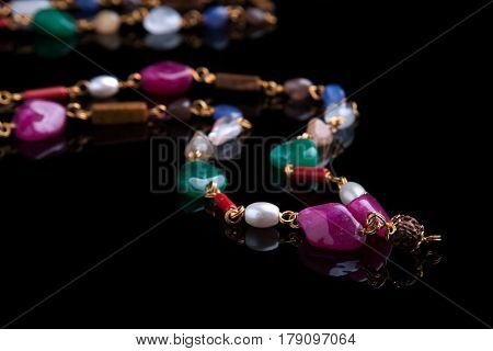 Beads with multi-colored stones on a black background