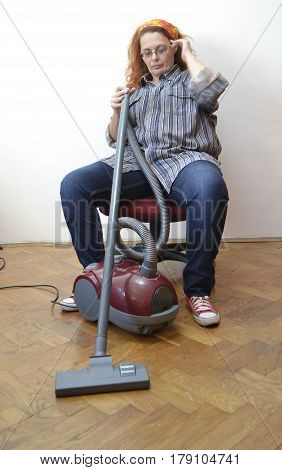Housewife with vacuum cleaner rest from hard work