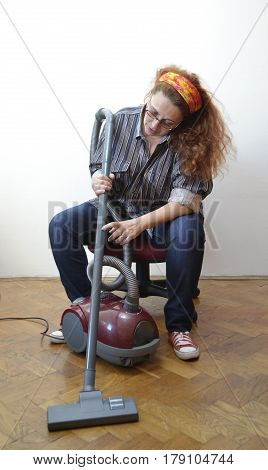 Housewife with vacuum cleaner rest from hard work