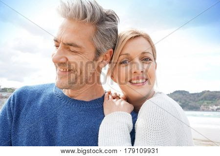 Middle-aged couple embracing each other at the beach