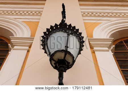 Wrought lantern on the wall of a classical building. Bottom view. Looks like a bumpkin