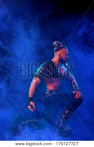 Handsome young sexy man with beautiful muscular chest in interesting costume on the scene. The Stripper man. Show time