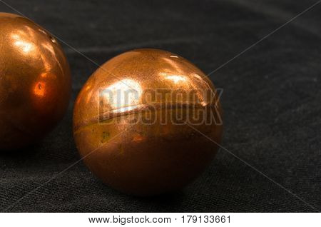 pair of copper Chinese singing balls Baoding of health for hands on black background