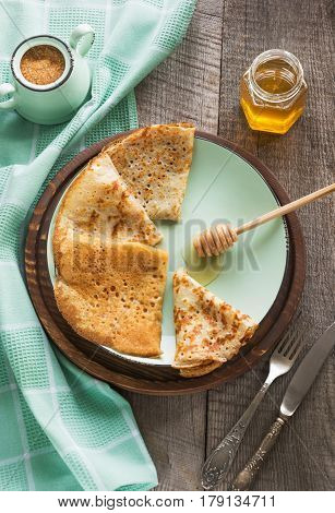 Tasty traditional russian breakfast of slapjack with honey on plate. Rustic style. Space for your text.