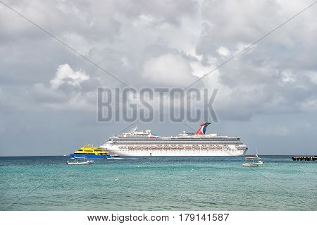 Cozumel Mexico - December 24 2015: large cruise ship or liner in bay or harbor touristic passenger boat on water summer day on cloudy sky background with yachts and boats. traveling and vacation