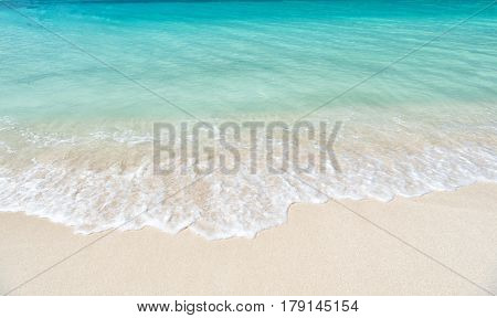 Beautiful marine view on ?aribbean sea coast line with clean wavy surf ocean water on sandy beach in st. john Antigua at sunny day as natural background