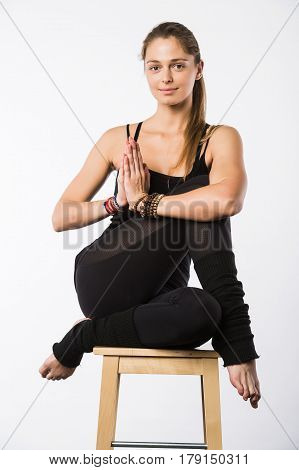 Sporty beautiful young woman sitting in Gomukhasana, Cowface pose, yin yoga Shoelace posture, asana for stretching hips and thighs, studio full length shot on white background, front view, isolated.