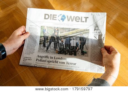 PARIS FRANCE - MAR 23 2017: Man reading German Die Welt newspaper featuring headlines following the terrorist incident in London at the Westminster Bridge