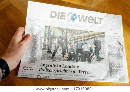PARIS FRANCE - MAR 23 2017: Man reading German Die Welt newspaper featuring headlines following the terrorist incident in London at the Westminster Bridge