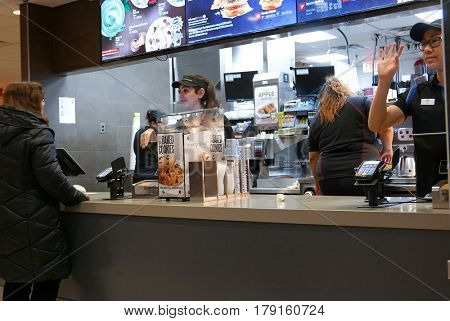 Coquitlam, BC, Canada - February 28, 2017 : Motion of worker waving for next on line customer at mcdonalds check out counter inside Coquitlam shopping mall