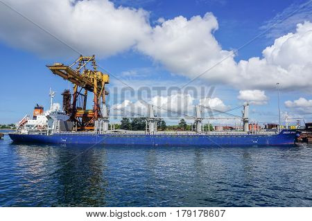 Labuan,Malaysia-Mac 25,2017:A large bulk carrier supplying iron ore being unloaded in Steel Mill Plant port at Labuan,Malaysia on 25th Mac 2017.