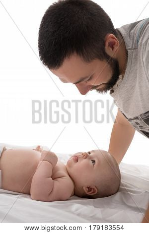Bearded young dad with newborn looking at him affectionately studio shot