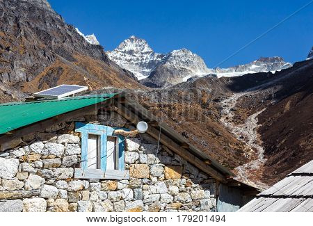 Mix of Modern Technologies and traditional rural Architecture in Nepal Mountains solar Cell and Internet Hot Spot on the wooden Roof of traditional handcrafted Stone Hut.