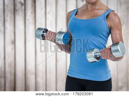 Digital composite of Woman weightlifting against blurry wood panel