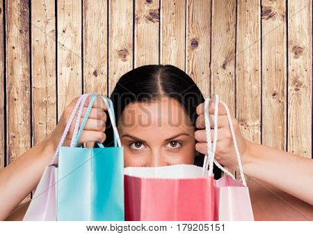 Digital composite of Woman with shopping bags against wood panel