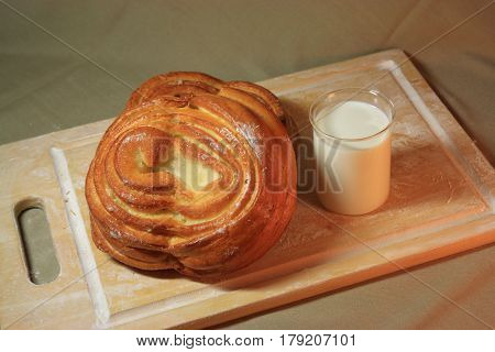 The process of baking. Ingredients. Flour into a bowl with a spoon and eggs in a plate rolling pin whisk strainer spices and milk on a wooden background. Spilling flour chaos confusion