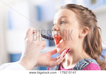 Cropped Shot Of Woman Doctor Checking Throat Of Little Girl